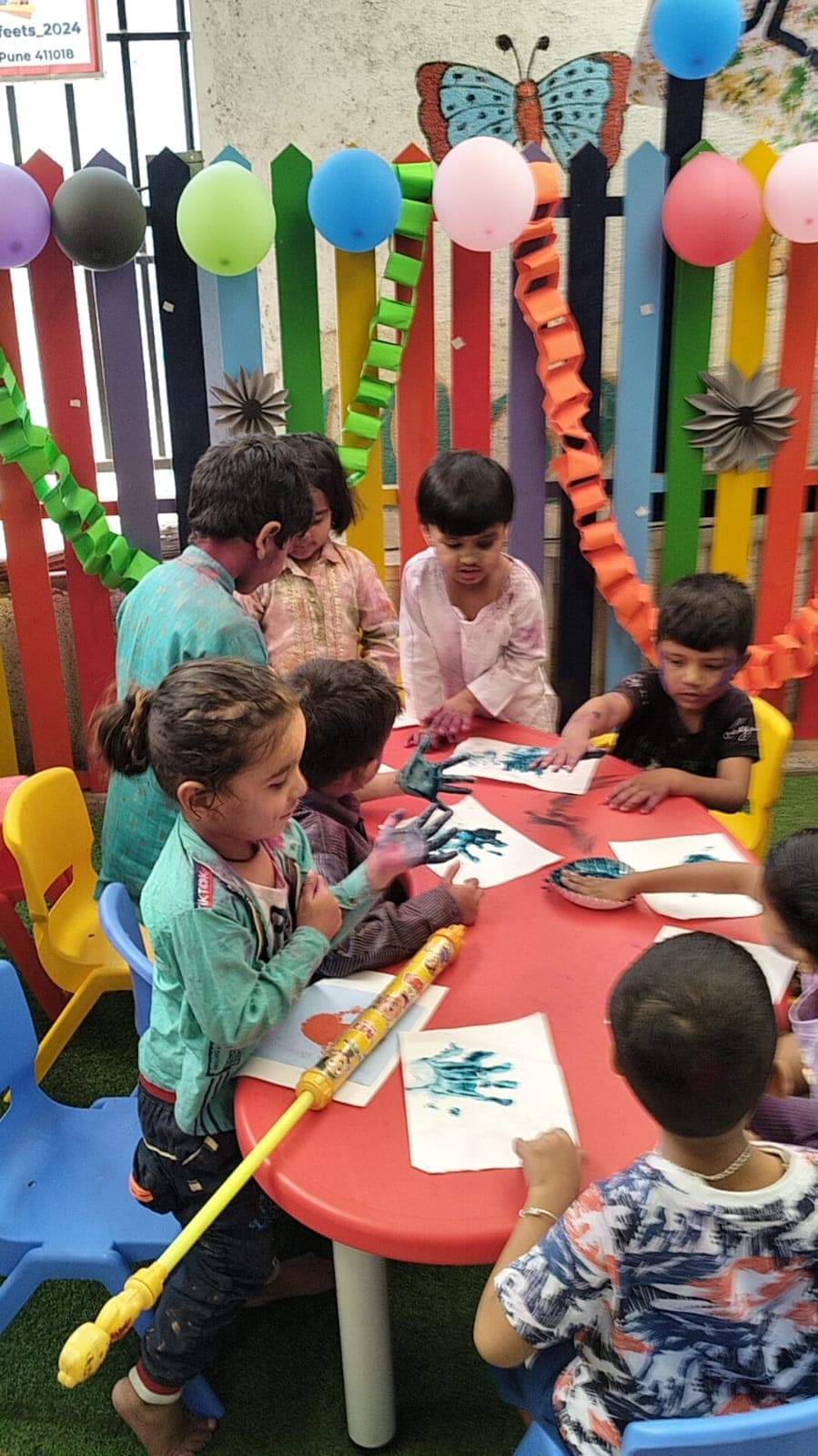 Children making handprint art during classroom activity
